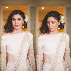 a woman wearing a white sari with flowers in her hair