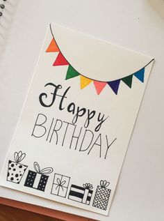 a happy birthday card on top of a desk next to a pen and laptop computer