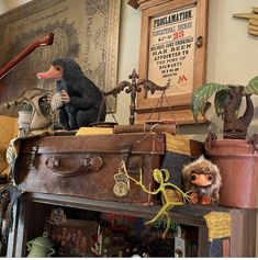 an antique trunk with stuffed animals on top and other antiques in the background, including figurines