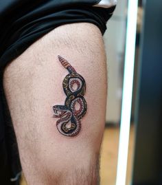 a man with a snake tattoo on his leg