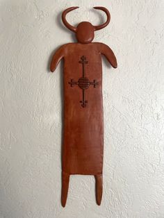 a wooden sculpture is hanging on the wall