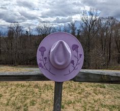 This lavender hand burnt wide brim fedora would make a perfect addition to any nature lover's  wardrobe. The faux suede lavender material burns a dark purple allowing the design to stand out. On both sides of the brim of the hat I hand burnt and shaded thistle flowers. The design is original and completely free-handed. For the finishing touch I added a bow hatband. Hat Materials: polyester Hat fits most with an adjustable tie band inside Size: 57-58cm Wide Brim: roughly 4 inches *Disclaimer* col Country Clothes, Cottagecore Gifts, Hand Burn, Thistle Flower, Hat Fits, Wide Brim Fedora, Festival Clothing, Love Hat, Boho Gifts