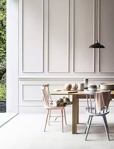 a dining room table with two chairs next to it