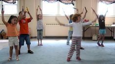 several children in a room with their arms up