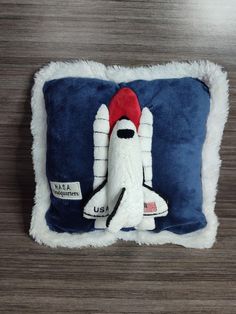 a stuffed space shuttle on a blue and white pillow