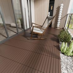 a rocking chair sitting on top of a wooden deck next to a plant filled with succulents