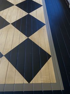 a black and white tiled floor next to a building