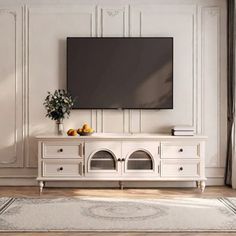 a large flat screen tv mounted to the side of a white cabinet in a living room