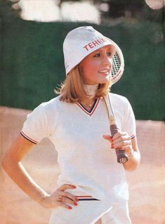 a young woman holding a tennis racquet on top of a tennis ball court