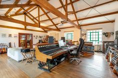 an old fashioned recording studio with wooden floors and exposed beams, large windows, and lots of equipment