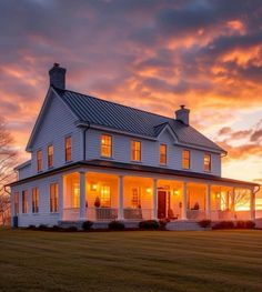 a large white house sitting on top of a lush green field under a cloudy sky