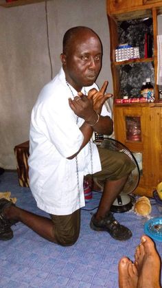 a man sitting on the floor making a peace sign