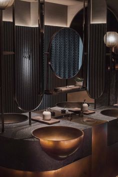 a bathroom with two sinks, mirrors and lights on the wall above it is an oval shaped sink