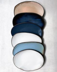 five blue and white plates stacked on top of each other in different shapes, sizes and colors