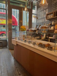 the inside of a restaurant with food and drinks on display in front of it's windows