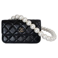 This 100% authentic Chanel Maxi Pearls clutch is crafted from black quilted calfskin leather, featuring a chic faux pearl strap and elegant silver-tone hardware with the signature CC detail on the front. It closes with a magnetic snap under the flap for easy access. The interior is lined in grosgrain fabric and includes a zipper pocket against the front and an open pocket against the back, combining timeless Chanel elegance with functional storage. Has been carried and is in virtually new condit Chanel Pearl Crush, Chanel Maxi, Chanel 2020, Raffia Crochet, Vintage Chanel Bag, Chanel Pearl, Pearl Clutch, Chanel Brand, Chanel Pearls