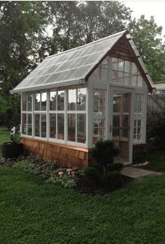 a small house with lots of windows in the yard