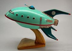 a toy model of a green airplane on a wooden stand