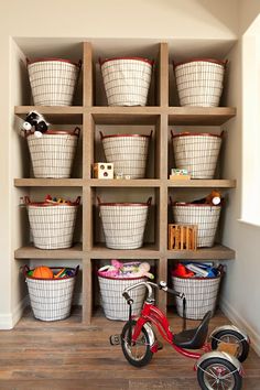 a bike is parked in front of a shelf filled with baskets and other items on the floor