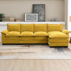 a yellow couch sitting in front of a white shelf on top of a hard wood floor