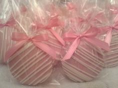 three heart shaped candys wrapped in plastic with pink ribbons and bows on them are sitting next to each other