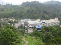 a cable car going up the side of a mountain in front of a large building