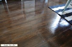 a black and white striped rug sitting on top of a wooden floor next to a chair