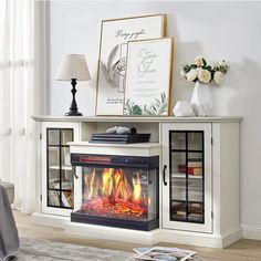 a living room with a fire place in the center and pictures on the wall above it