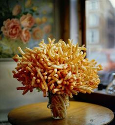 a vase filled with lots of fries sitting on top of a table