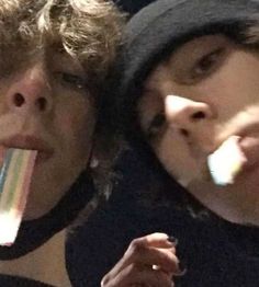 two people with their mouths open and one is eating an ice cream bar