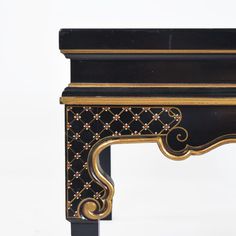 an ornate black and gold painted table