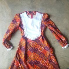 "Super adorable vintage 70 Hippie Dress - bold orange-y red multicolor patchwork print dress with white bib collar - def get this favorite before the weather cools in my area, at which point, it will probably disappear into my closet for a spell no tags - appears to be handmade 70s feels like a light to med weight polyester knit - more of a fall winter than summer feelin' fabric sash ties attach to the bib collar to tie in back back zipper size/fit estimated fit s-m armpit 19\" waist 21\" sash t White Retro Dress For Fall, Retro Patchwork Dress For Fall, Vintage Red Patchwork Dress, Vintage Red Dress With Patchwork, Retro Red Patchwork Dresses, Red Vintage Dress With Patchwork, 21 Sash, Bohemian Crochet Dress, Hippie Dresses Boho