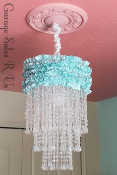 a chandelier hanging from the ceiling in a room with pink and blue walls