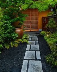 an outdoor garden with stone walkways and plants in the foreground, surrounded by tall trees