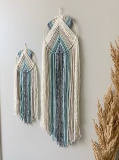 two wall hangings made from macrame beads and tassels hang on the wall