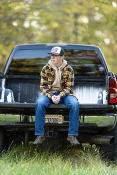 a man sitting on the back of a pickup truck