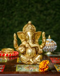 an elephant statue sitting on top of a wooden table next to other decorations and flowers