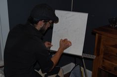 a man sitting in front of a drawing board