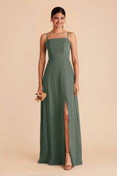 a woman in a long green dress with one leg slited out and the other side split