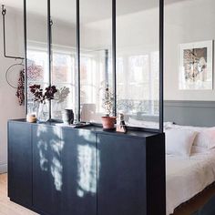 a bed room with a large mirror on the wall next to it and vases