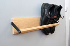 a pair of black shoes hanging on a wall with a shoe rack attached to it