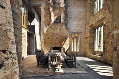 an old stone building with tables and chairs in the center, surrounded by brick walls