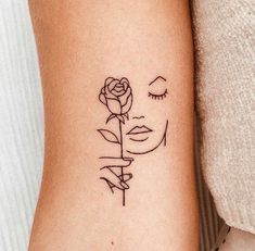 a woman's arm with a rose tattoo on it