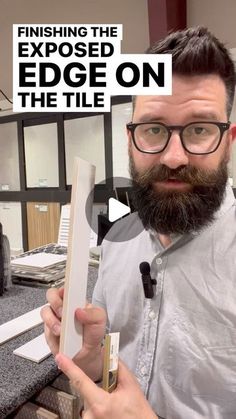 a man holding up a piece of paper with the title finishing the exposed edge on the tile