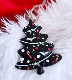 a black christmas tree ornament with skulls and candy canes on the bottom