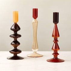 three different colored candles sitting next to each other