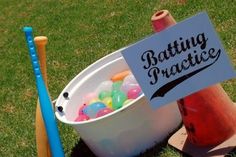 a bucket filled with lots of candy next to a sign that says batting practice on it