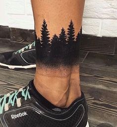 a person's leg with trees on it and the words reebok written in black ink