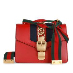 The Gucci Sylvie is one of those bags that became a classic the moment it landed in stores. Featuring the brand’s signature green and red front fabric stripe and a charming gold tone hardware chain strap, this mini Gucci is an absolute must-have, and iconic piece to own from the brand. SPL Exterior Smooth Red leather Gold toned hardware Chain buckle detail on front flap Red and navy fabric strip Gold tone chain crossbody strap Removable ribbon Excellent condition - minimal signs of wear except some hairline scratches to the hardware and closure. One small scratch to front left. Interior Beige microfibre suede like interior Single compartment Slip pocket Gucci embossed leather logo tag Excellent condition - small press mark under flap, inside is clean. Sold on its own SPL Height: 14cm Width Gucci Sylvie, Gucci Mini, Navy Fabric, Dior Shoes, Green And Red, Chain Bag, Timeless Handbag, Exclusive Bag, Chain Bags