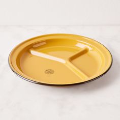 a yellow plate on a white table